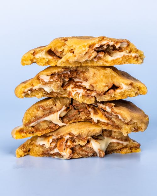 Free Close-up of stacked homemade cookies with a creamy filling against a blue background. Stock Photo
