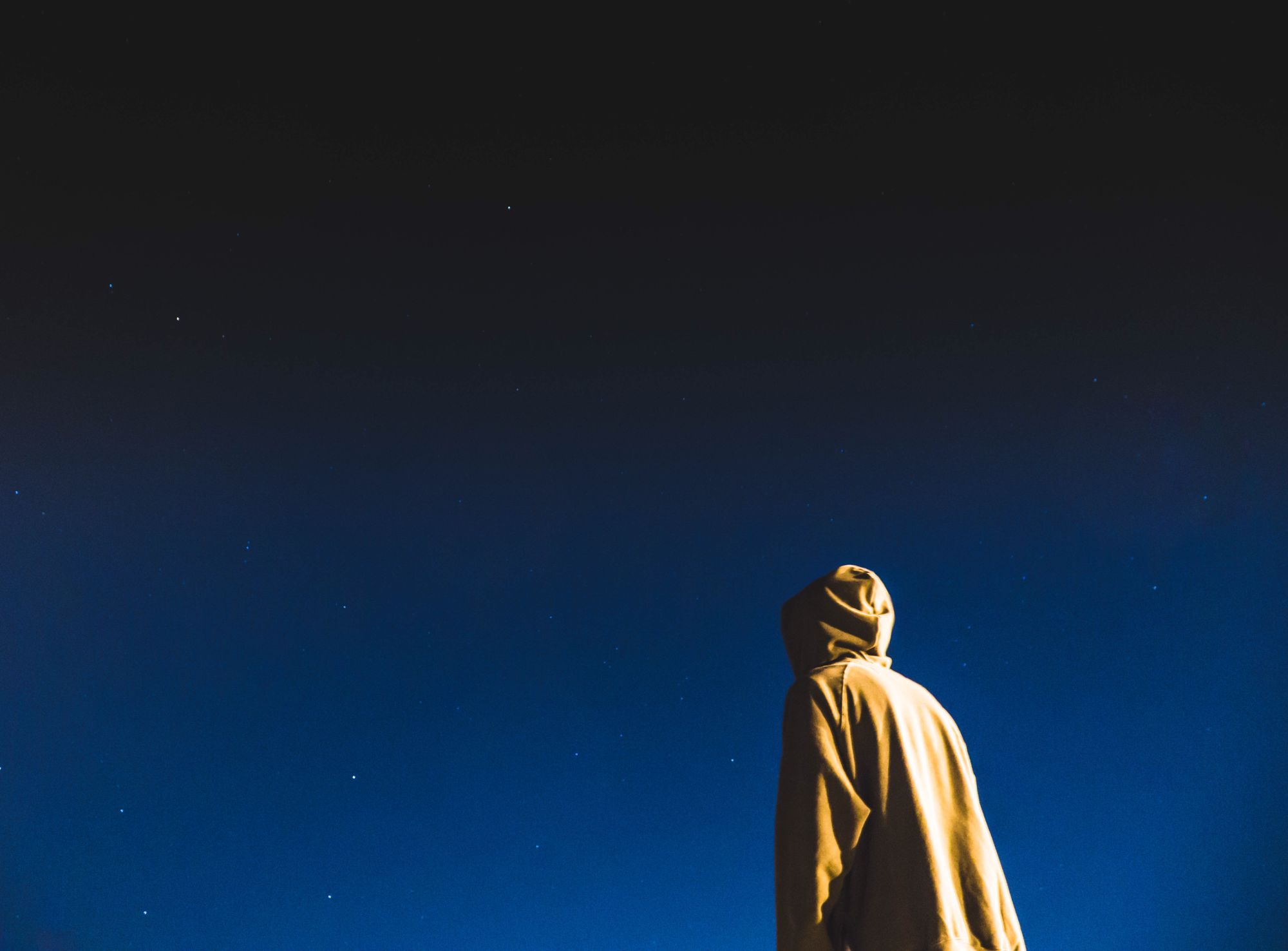 Silueta de una persona observando un cielo nocturno lleno de estrellas