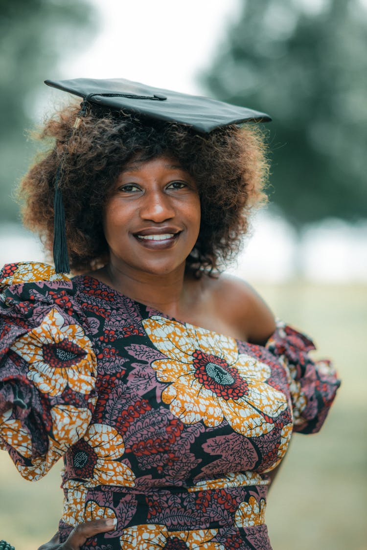 Young Woman In A Dress And A Mortarboard Posing Outside