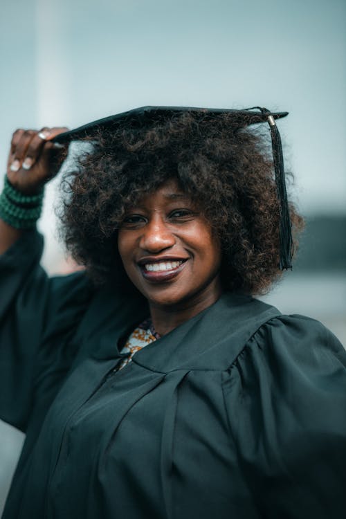Portrait of a Smiling Woman Wearing a Graduation Gown and Mortarboard
