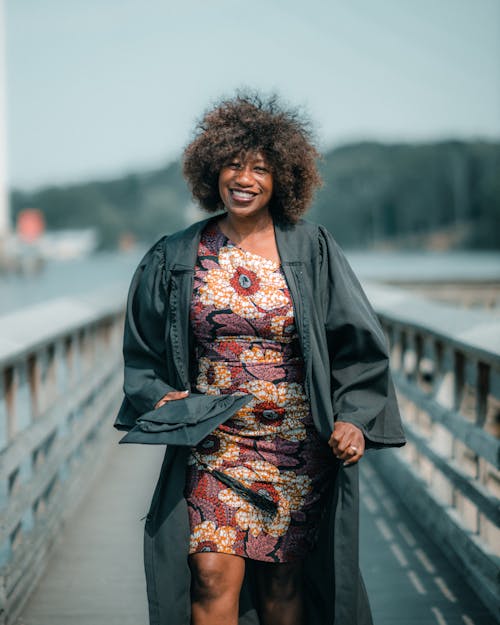 Woman in a Graduation Gown and a Cap in her Hand 