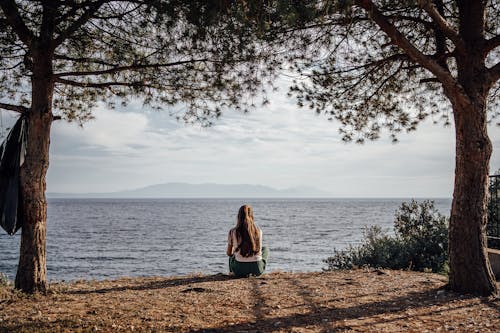 Woman Sitting and Looking at the Lake 
