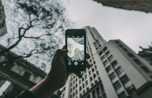 Free Person Holding Iphone Near Building Stock Photo