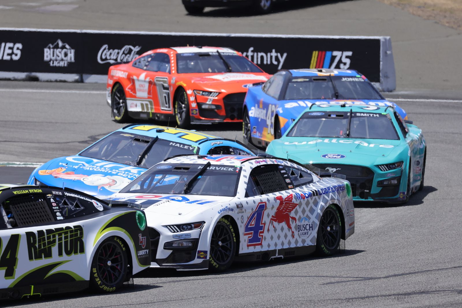 NASCAR Cup Series cars racing nose to tail through a corner