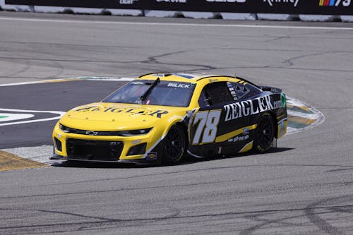 Free Yellow and black Chevrolet car in action on a motorsport circuit during a race event. Stock Photo