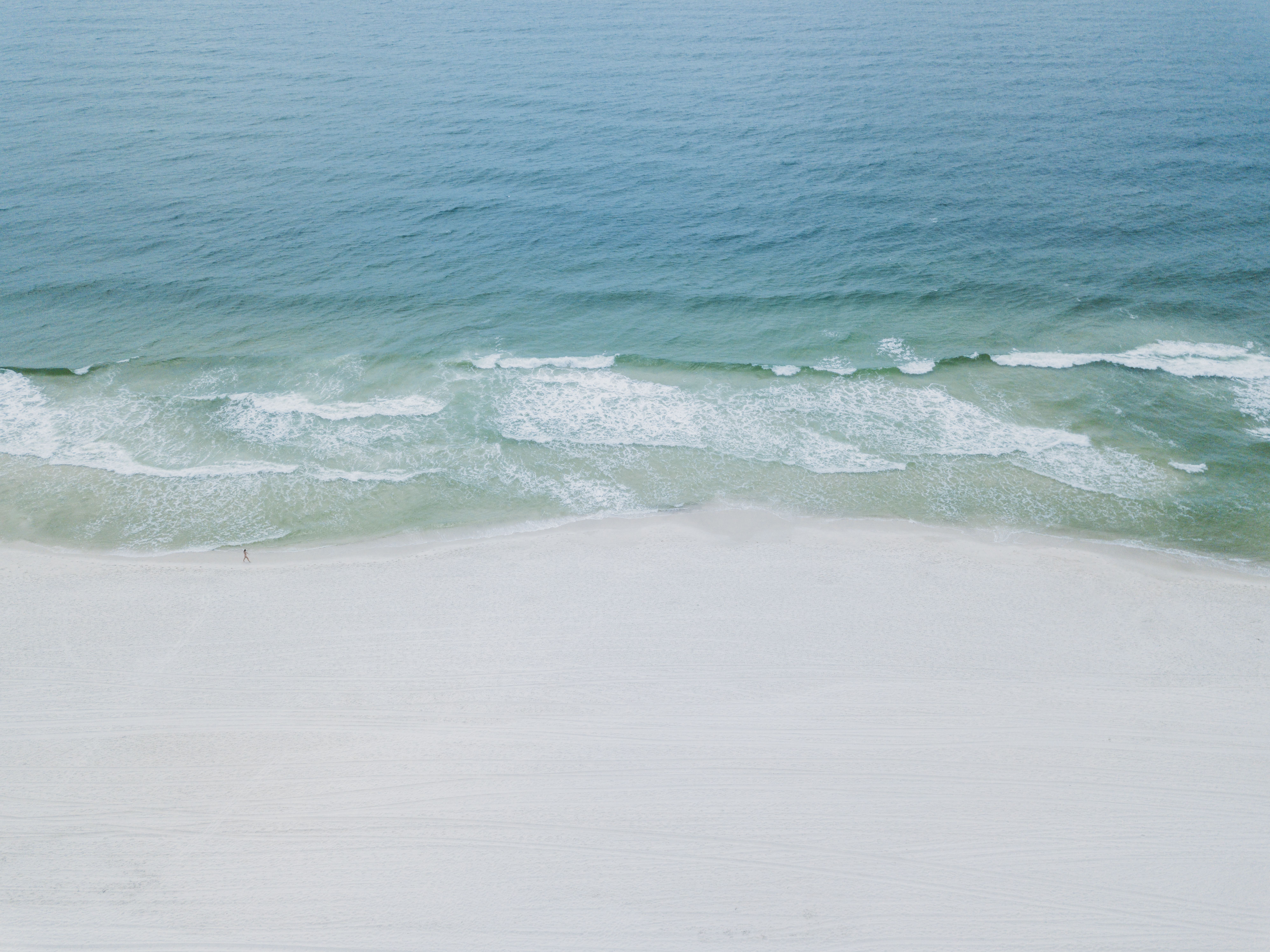 A serene aerial image showcasing the tranquil beaches and clear waters of Orange Beach, Alabama.
