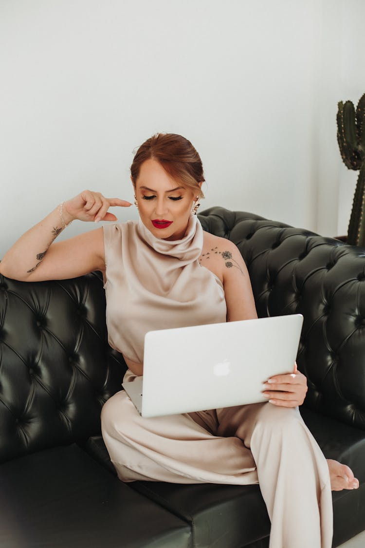 Woman Sitting On Couch And Posing With Laptop