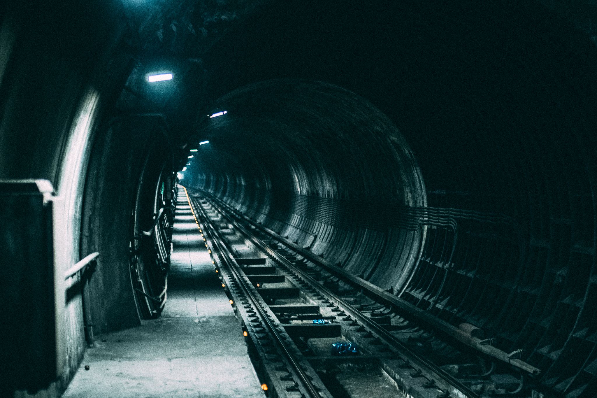 Dimly lit railway tunnel creates a dramatic and mysterious atmosphere.