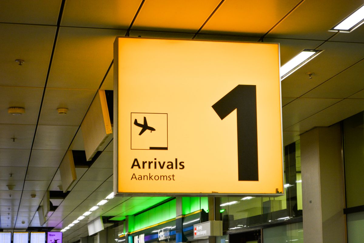 Bright arrivals sign with an airplane symbol in an airport terminal