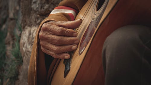 Elderly Man Hand Playing Acoustic Guitar