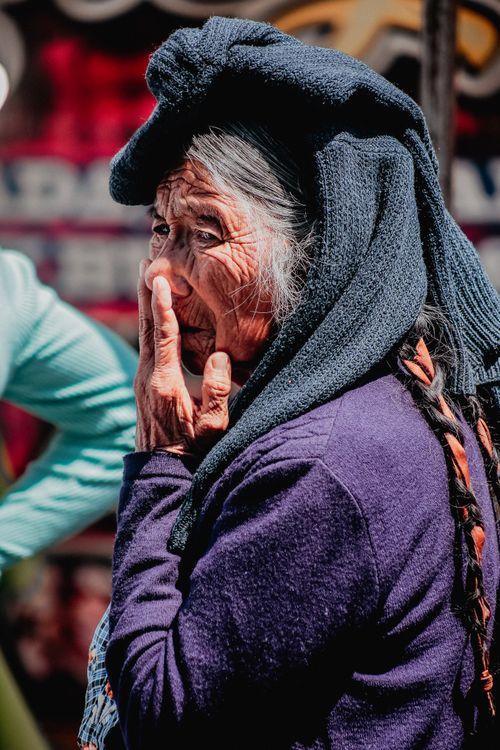 Free Portrait of an elderly woman in Puebla, Mexico, wearing a headscarf, captured in vibrant colors outdoors. Stock Photo