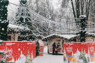 圣诞市场白雪皑皑，装饰着节日饰品，摆满了节日摊位