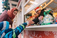 圣诞市场上，母亲和孩子在摊位前挑选糖果，洋溢着节日气氛