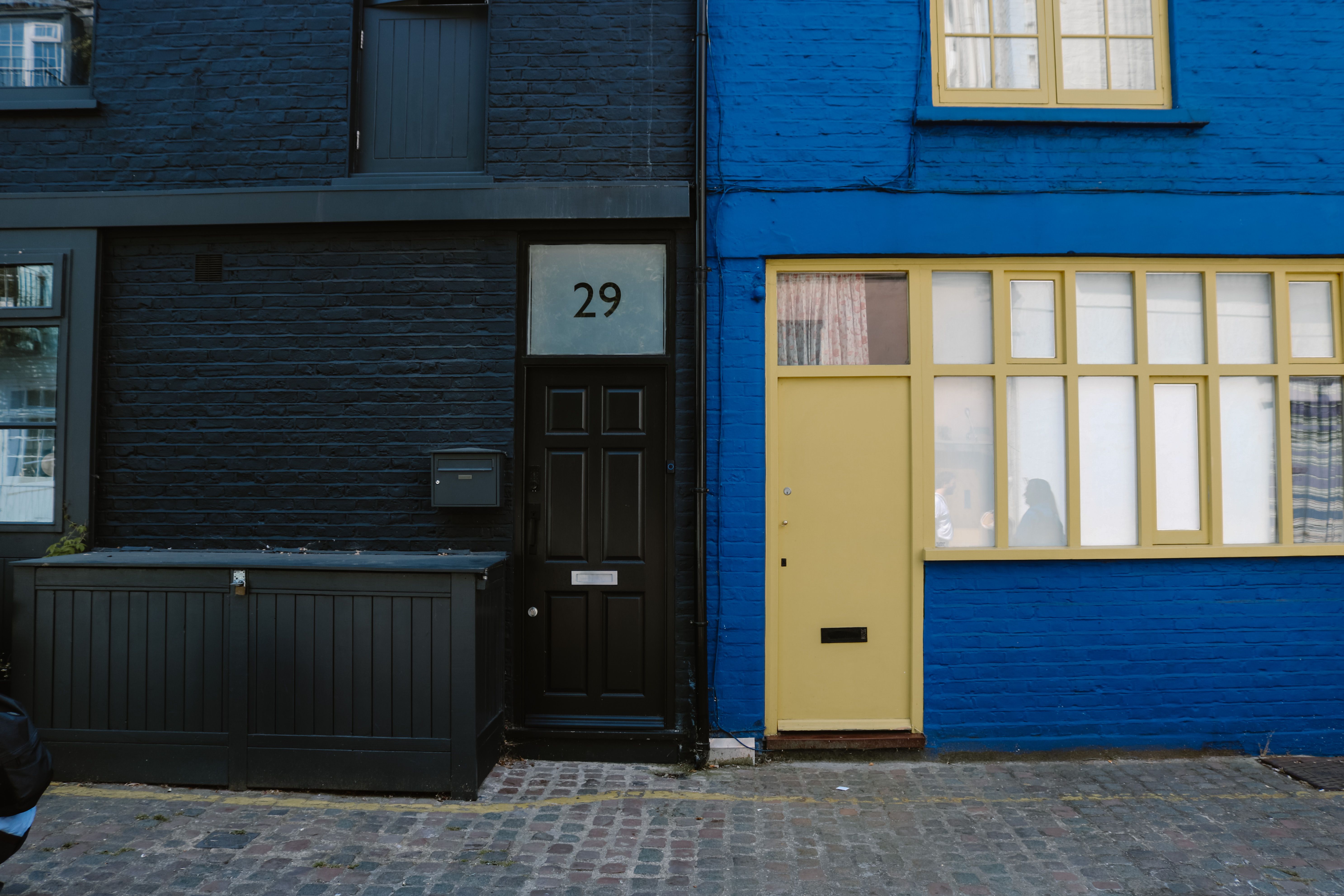 Colorful urban house facades with contrasting black and blue exteriors in a quaint street setting.