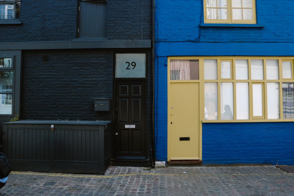 Colorful urban house facades with contrasting black and blue exteriors in a quaint street setting.