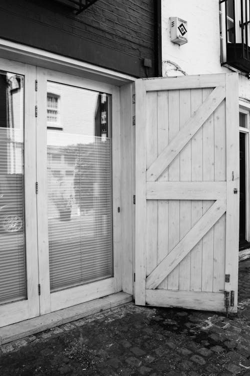 Black and White Photo of Glass and Wooden Doors of an Old House 