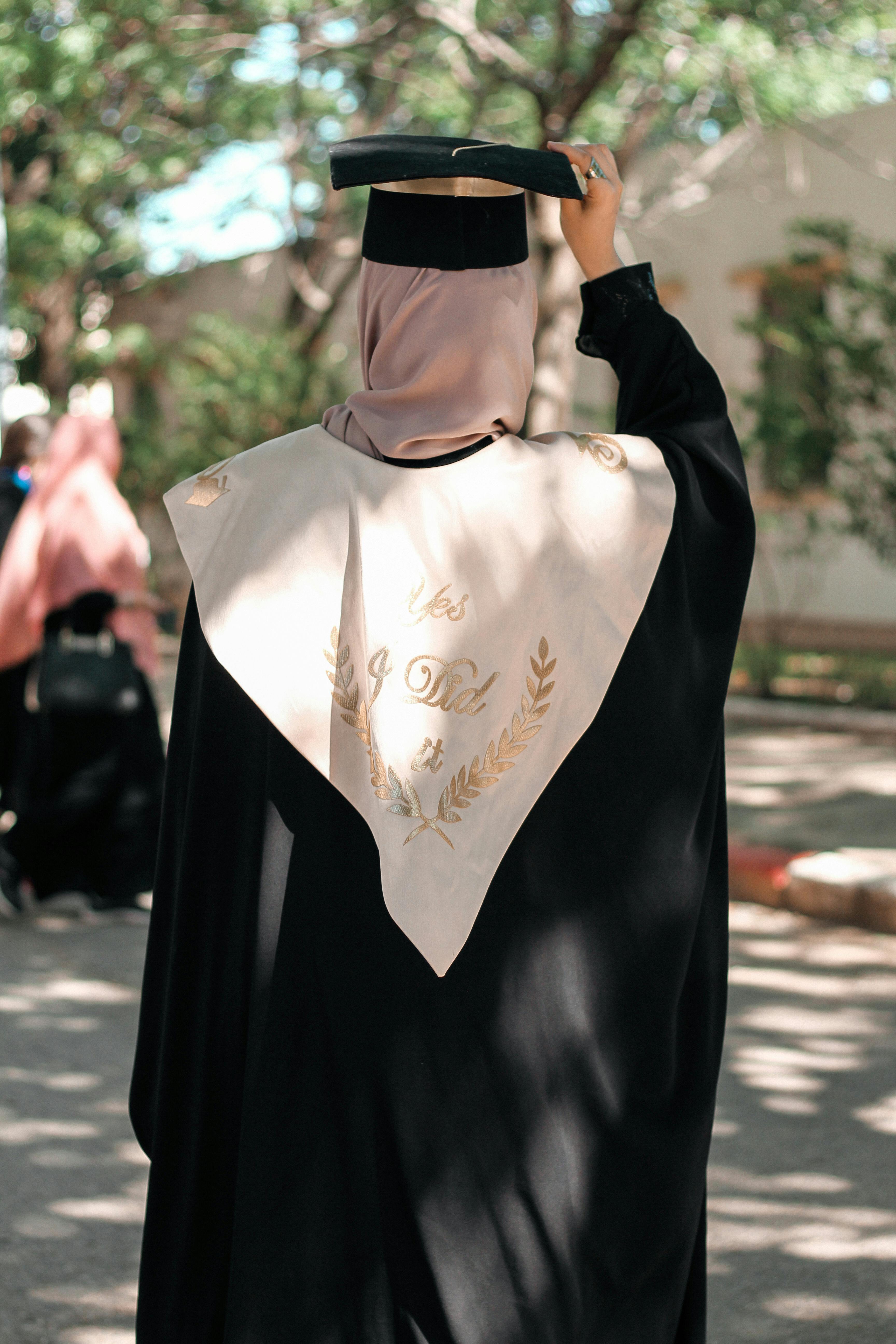Woman in a Graduation Gown Listening to a Speech · Free Stock Photo