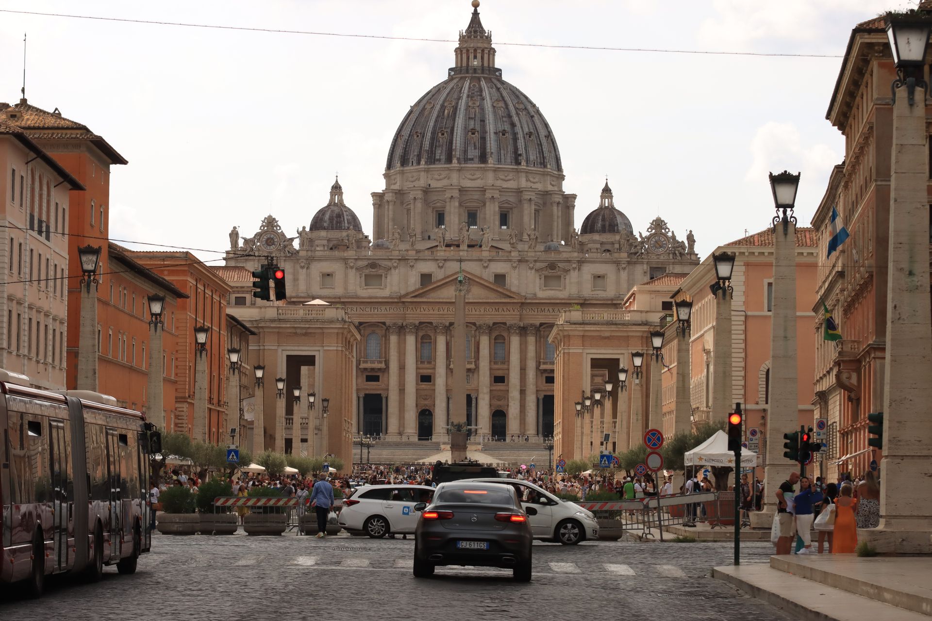 View of St. Peter's Basilica with bustling street scene in Vatican City, Italy.