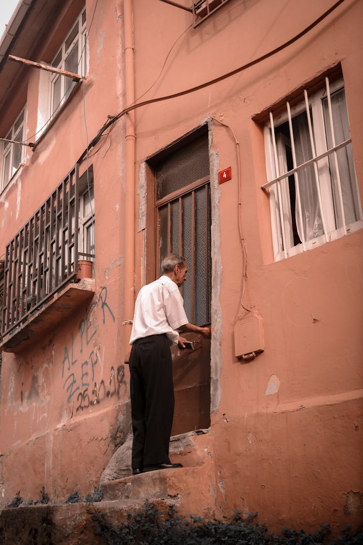 Man Standing By Building Door