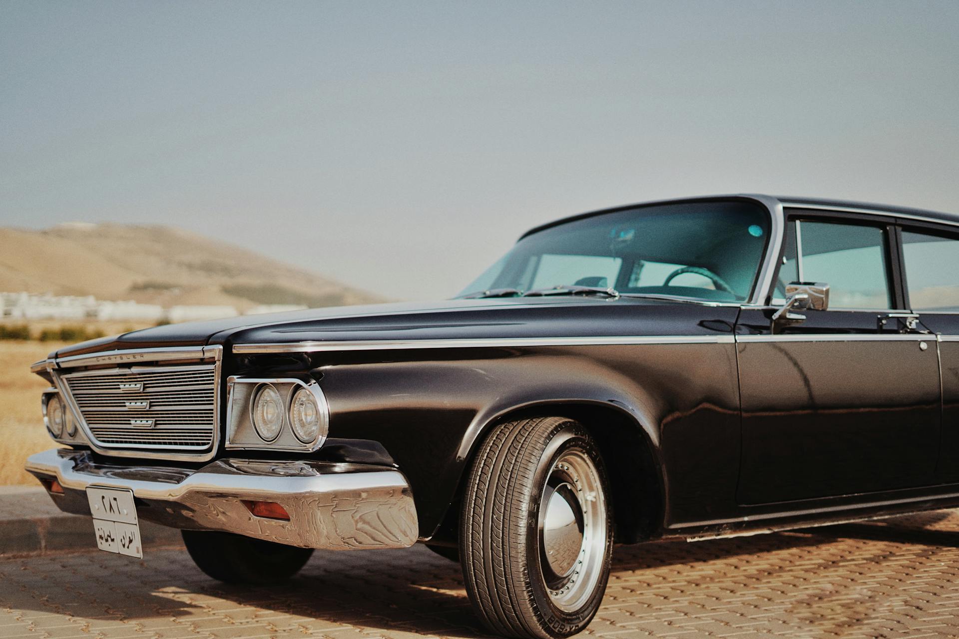 A classic Chrysler Newport car captured in a sunny outdoor setting, showcasing its vintage charm.