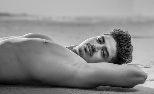 Young Shirtless Man Lying on the Sand 