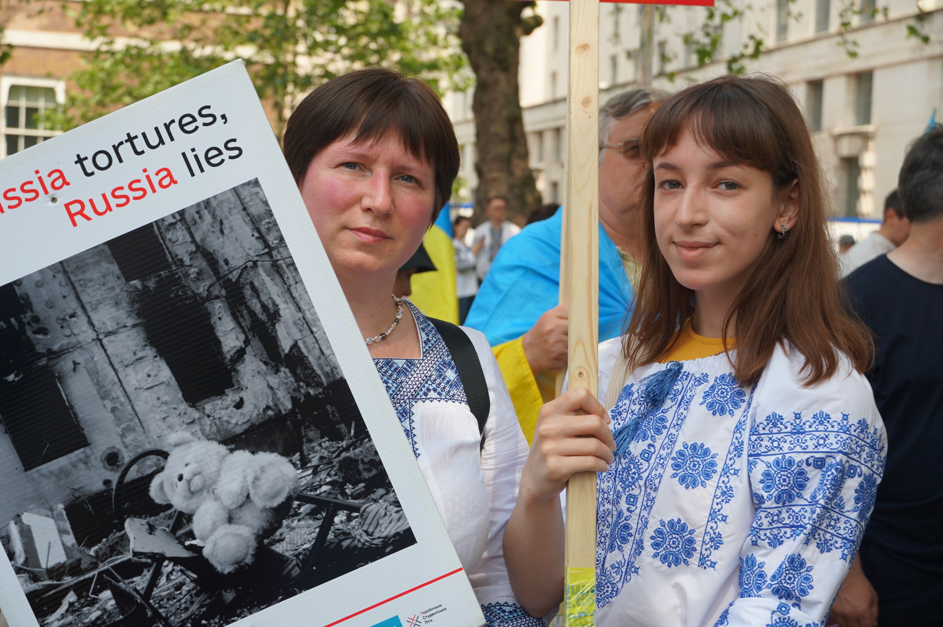 Ukrainian women protest against Russian aggression holding signs in London, England.
