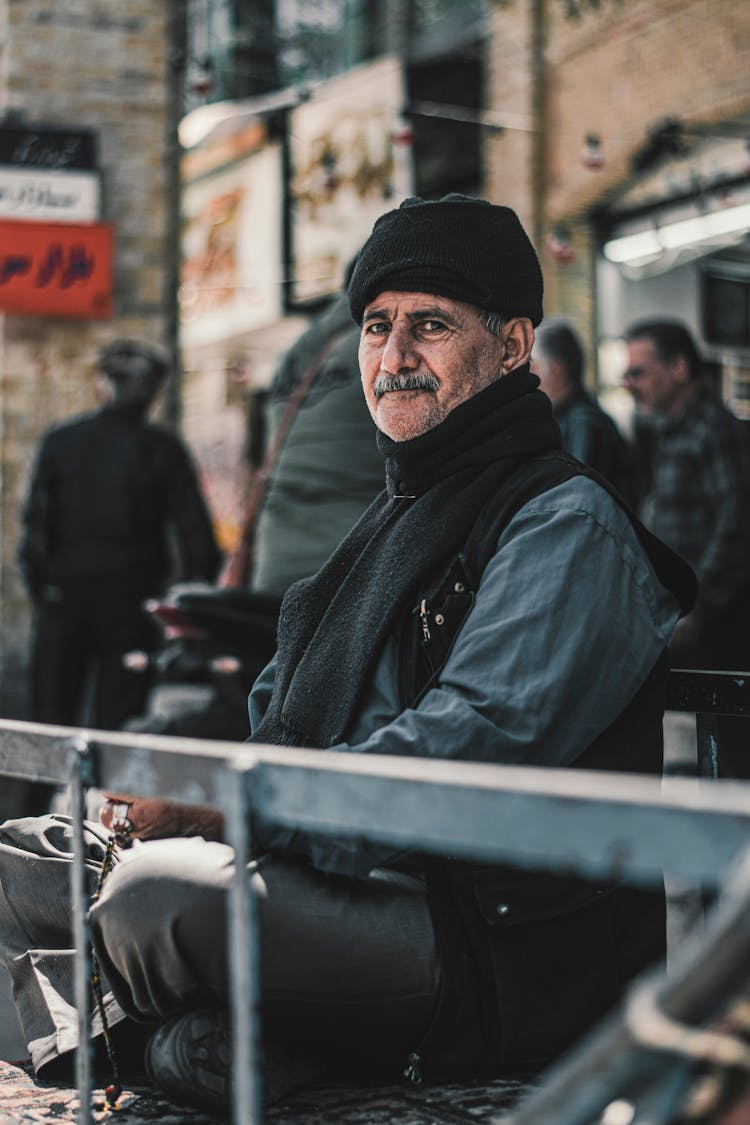 Man Sitting In Hat And Scarf