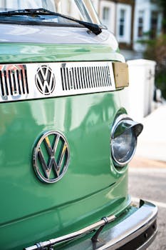 Close-up of a vintage Volkswagen camper van displaying its iconic logo outdoors.