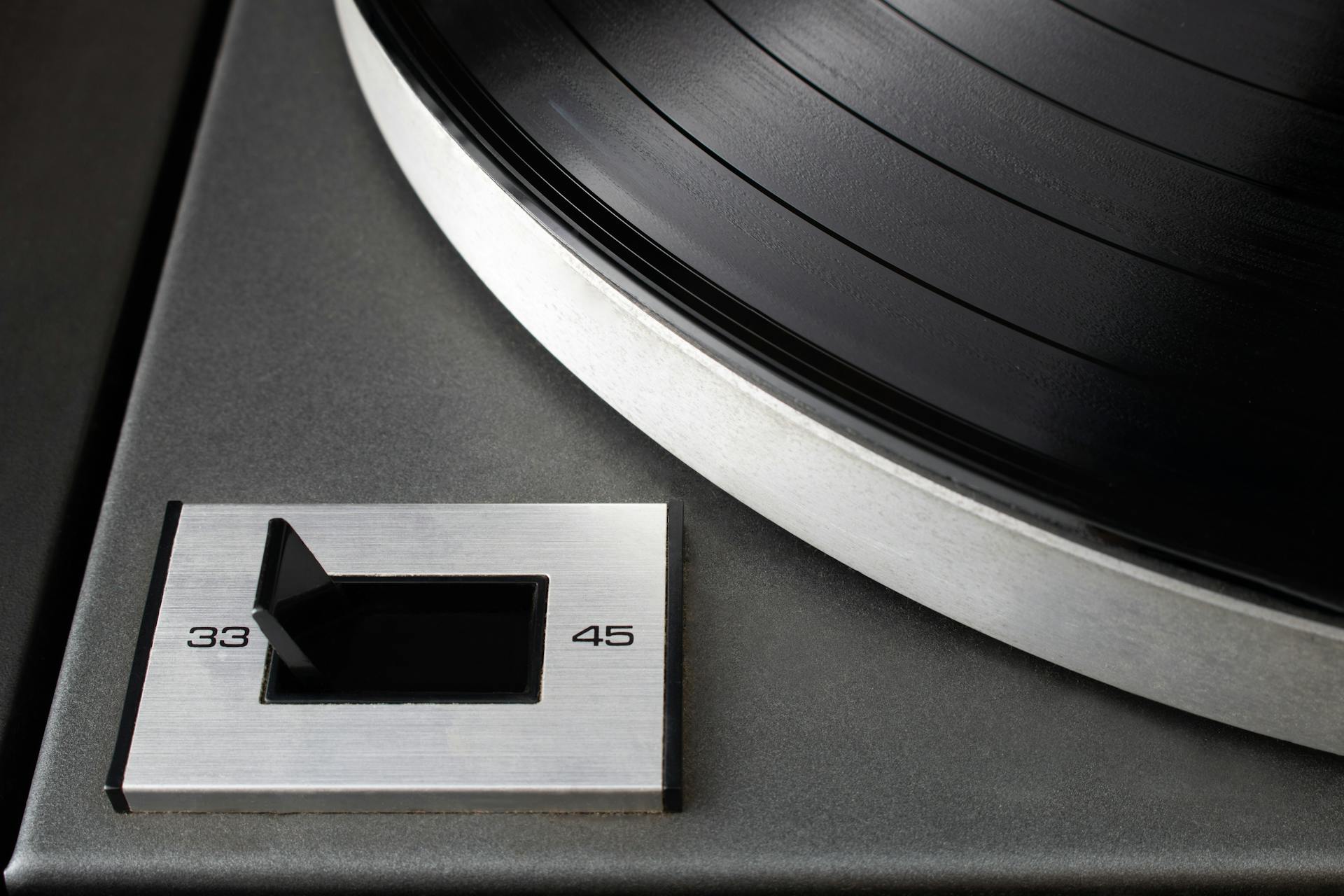 Macro shot of a vintage turntable with a speed selector for 33 and 45 RPM vinyl records.