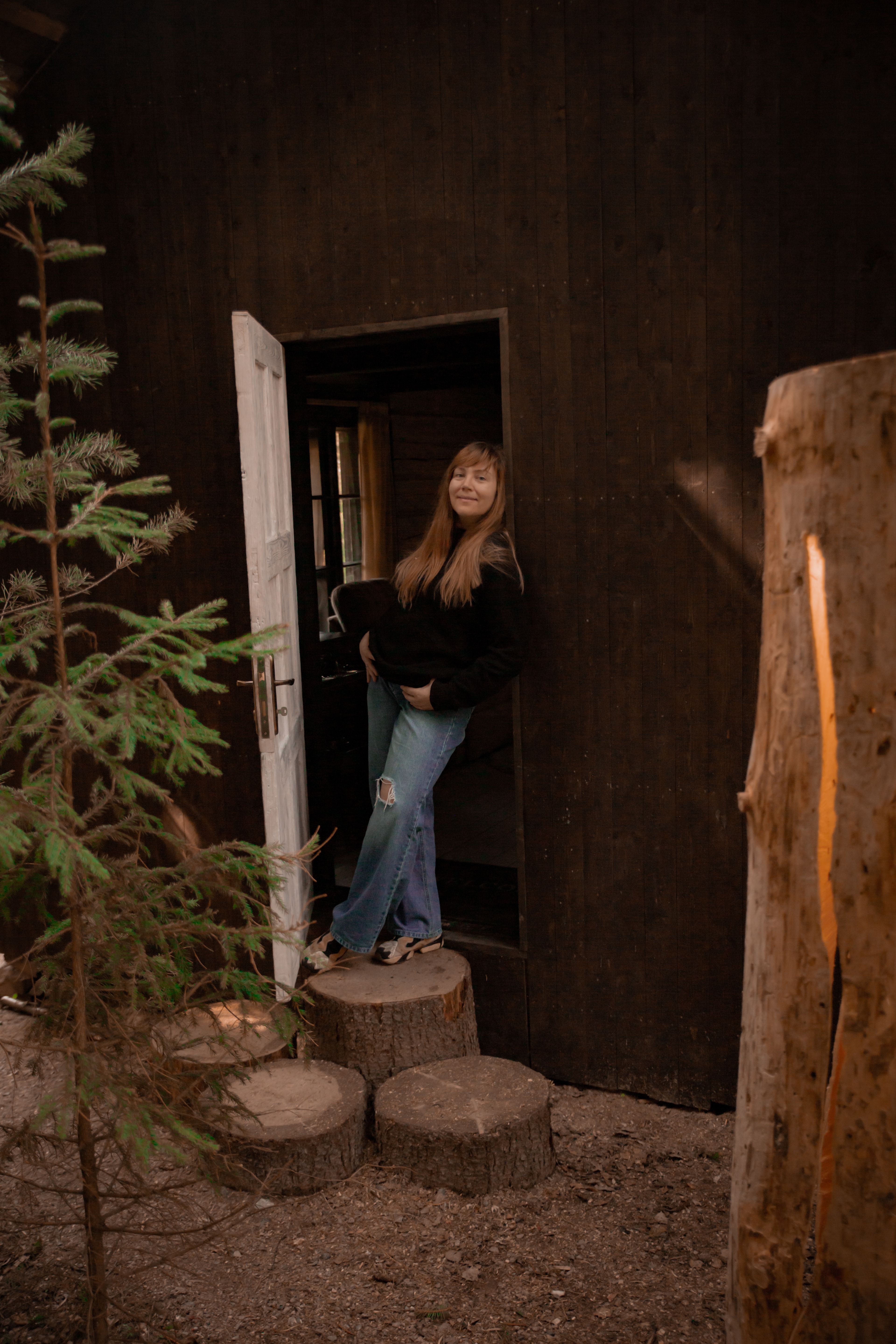Young Blonde Standing in a Doorway of a Wooden House · Free Stock Photo