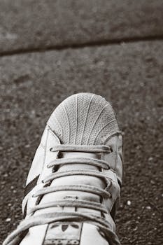 Detailed view of a sports shoe on concrete pavement. Focus on texture and design.