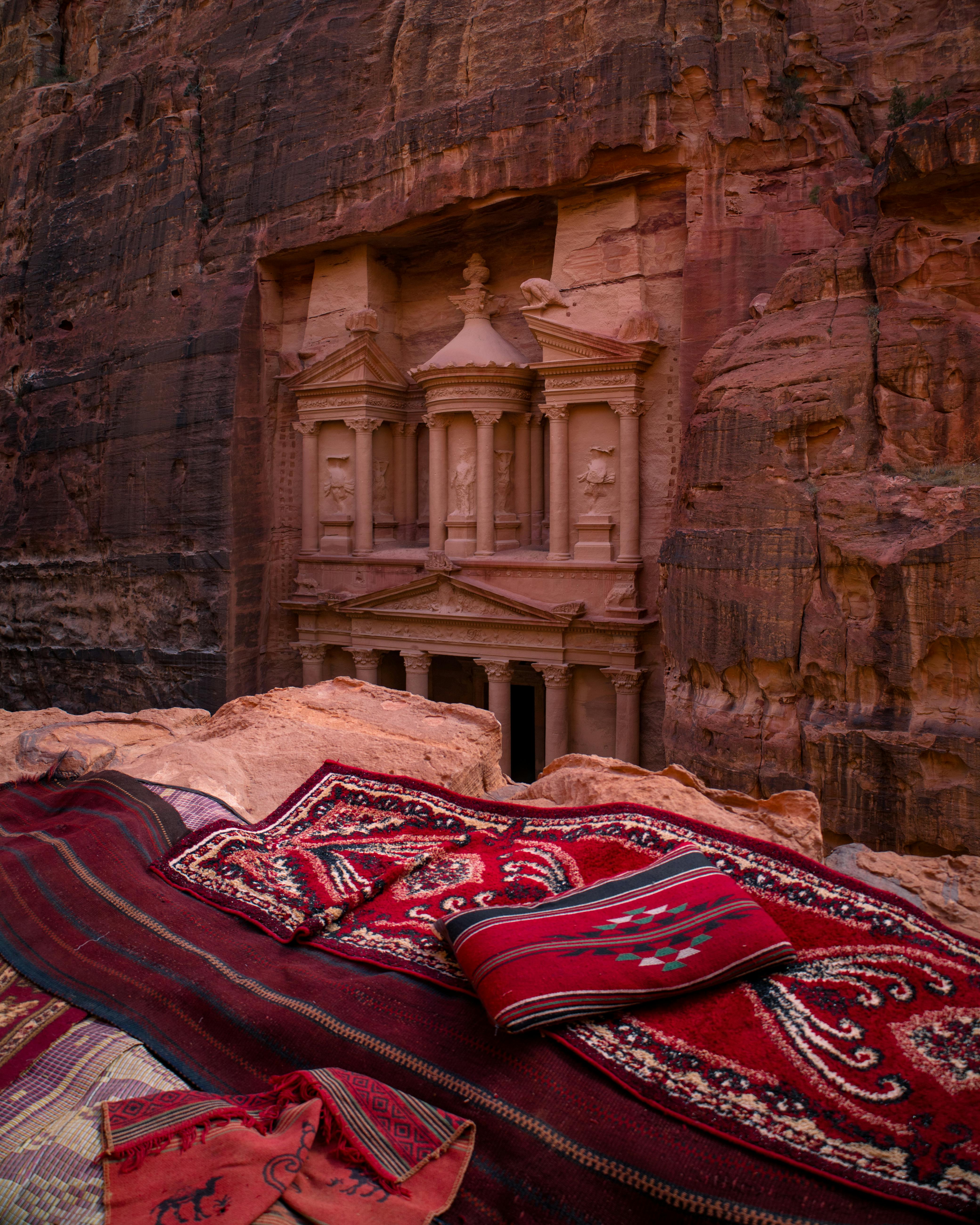 Vivid capture of Petra's Treasury, iconic Jordanian landmark, with traditional carpets.