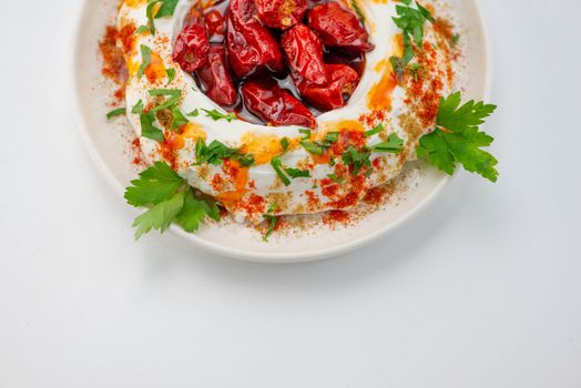 Delicious yogurt dip topped with red peppers, spices, and fresh herbs.