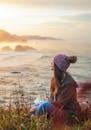 在俄勒冈州海岸，一名戴着帽子的女子正享受着宁静的海洋日落，放松身心