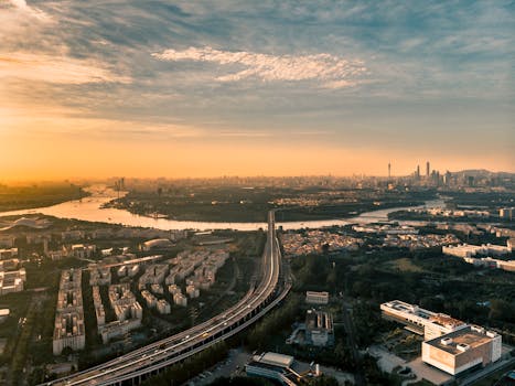 航拍捕捉了日出时分珠江与广州天际线的壮丽景观，展现了城市的建筑风貌