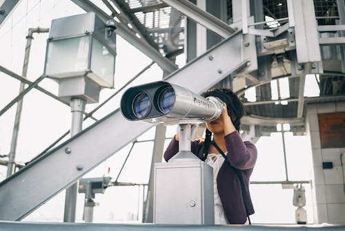 Free Woman in Purple Cardigan Using Binoculars Stock Photo