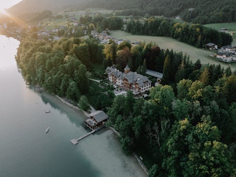 Aerial view of a majestic lakeside mansion in Salzburg, Austria during sunset.