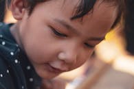 一幅温柔的特写肖像，展现了一个陷入沉思的小男孩的天真与好奇