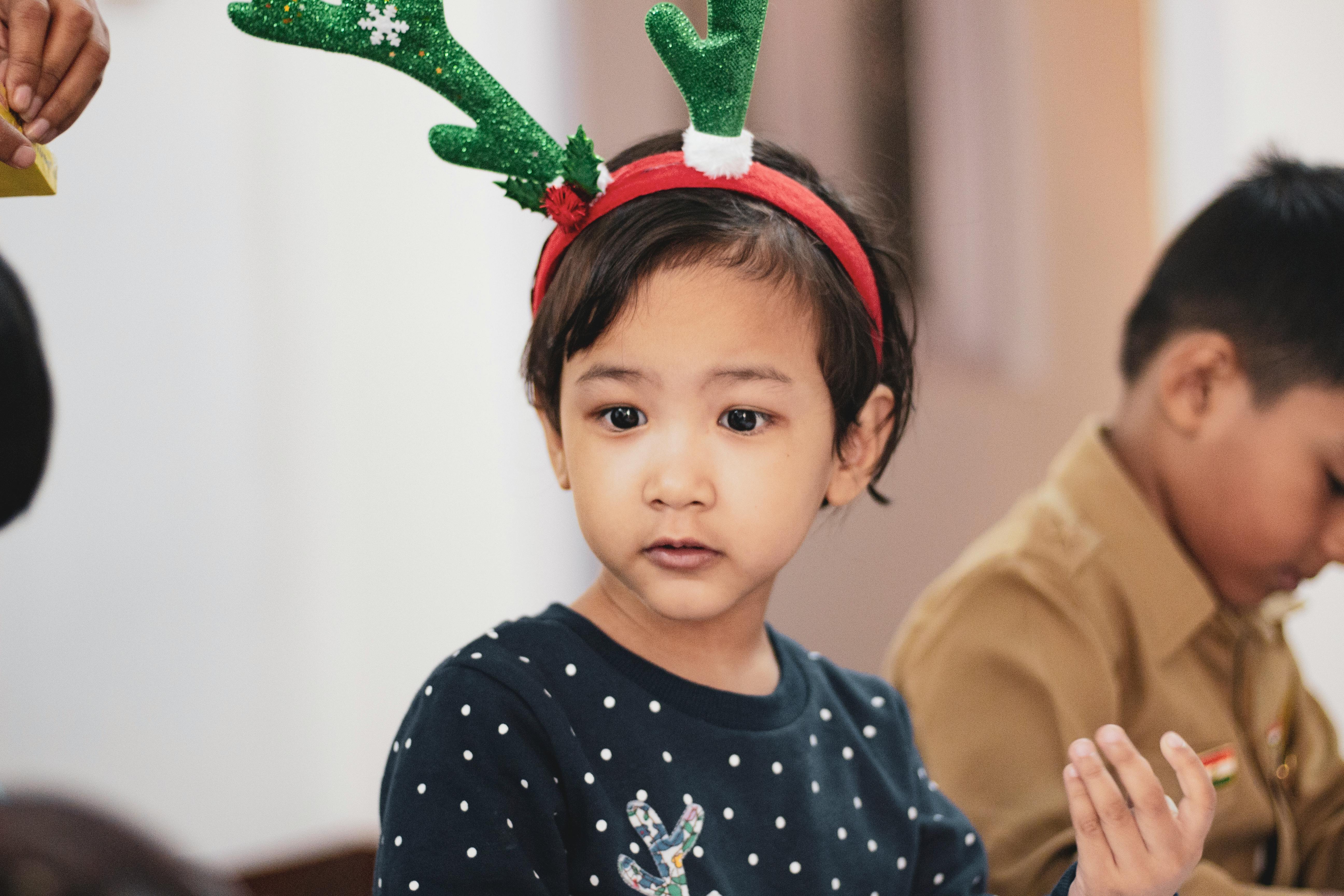 古瓦哈蒂的一次节日聚会上，一名年幼的孩子戴着驯鹿鹿角在室内