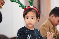 古瓦哈蒂的一次节日聚会上，一名年幼的孩子戴着驯鹿鹿角在室内