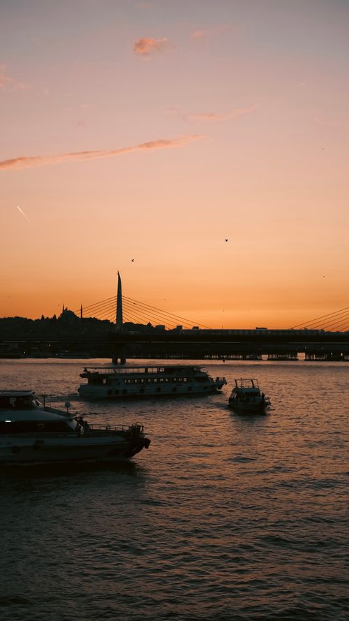 Free Charming sunset view of ferries on Istanbul's golden waterway, showcasing the city's skyline. Stock Photo