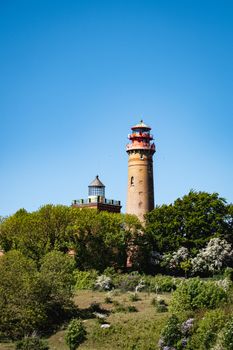 Scenic view of Cape Arkona lighthouses amidst lush greenery under a clear blue sky in Putgarten, Germany.
