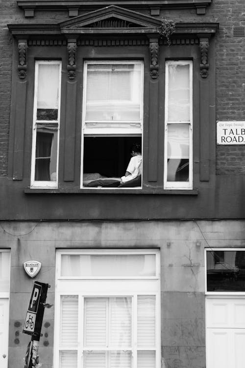 Person Sitting in Building Windows