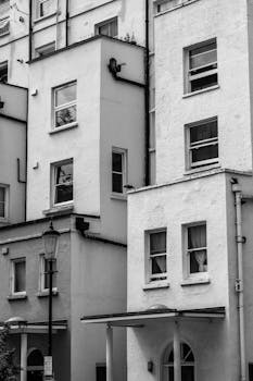 Classic black and white photo of urban apartment facades with windows and textures.
