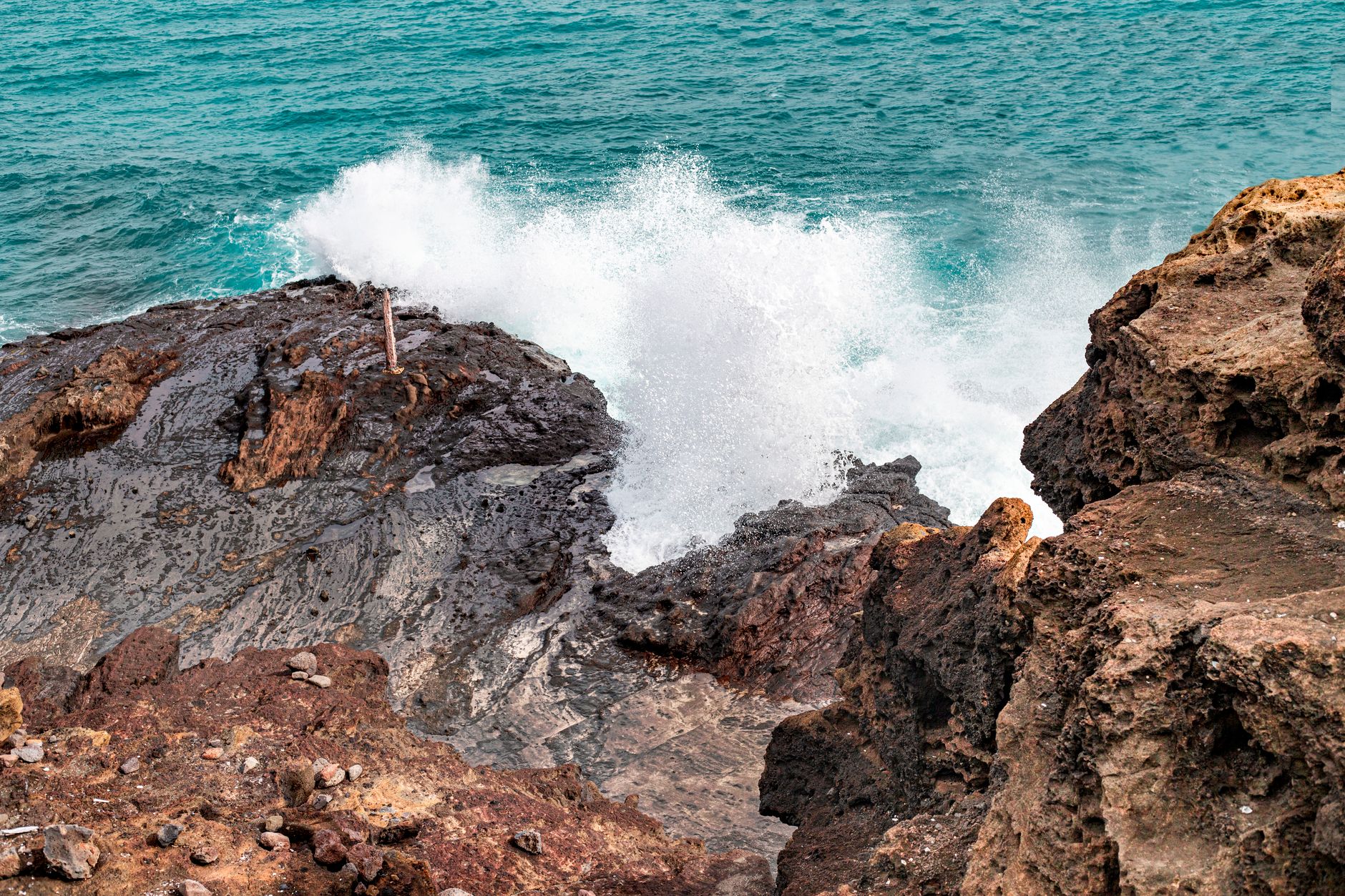 Waves crash against coastal rocks at Halona Blowhole, Oahu, Hawaii.