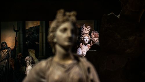 Free Intricate classical marble statues displayed in a dimly lit museum setting, showcasing artistic craftsmanship. Stock Photo