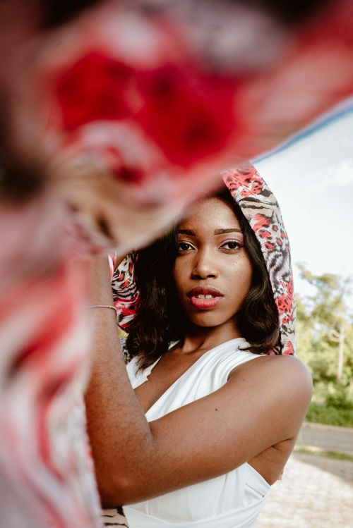 Free Stylish young woman modeling outdoors with a colorful scarf, capturing a serene and fashionable pose. Stock Photo