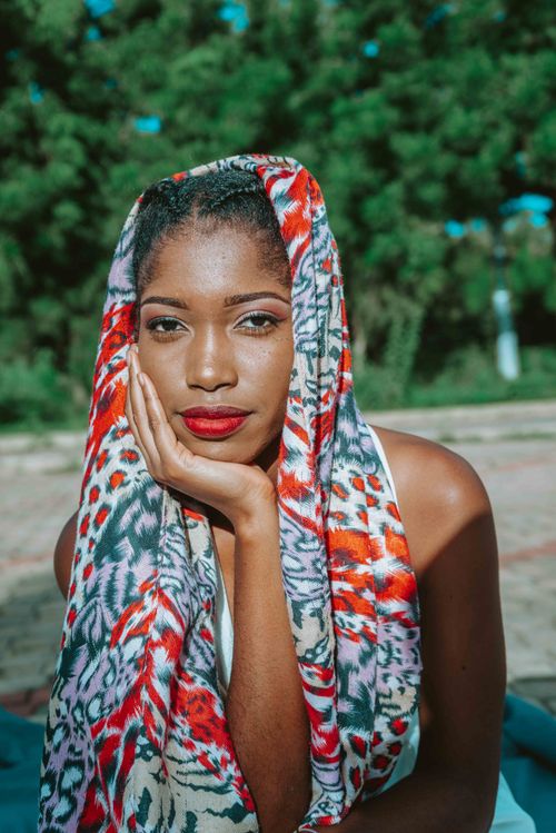 Free Elegant woman outdoors wearing a vibrant scarf, showcasing beauty and fashion. Stock Photo