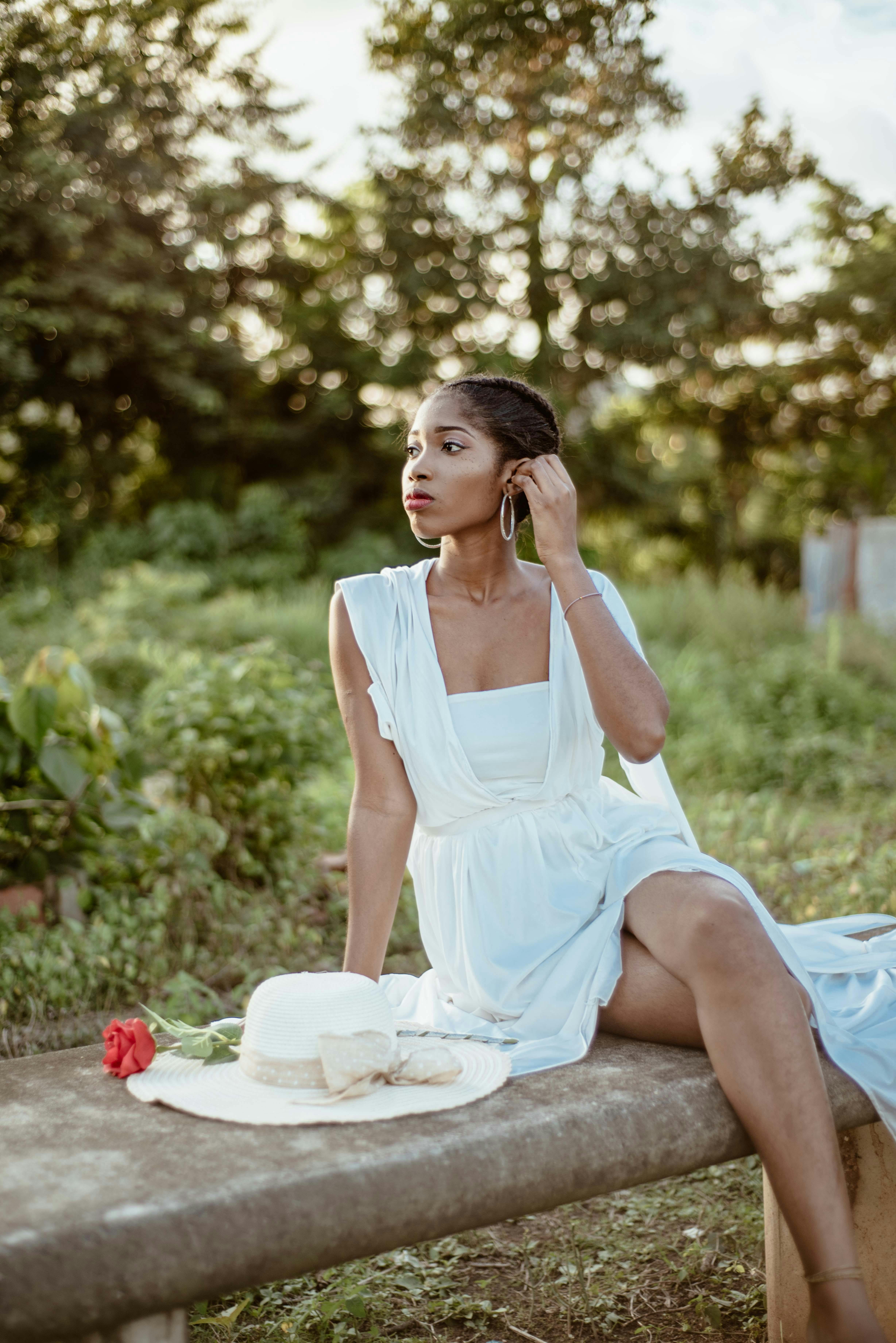 a woman in a white dress sitting on a bench