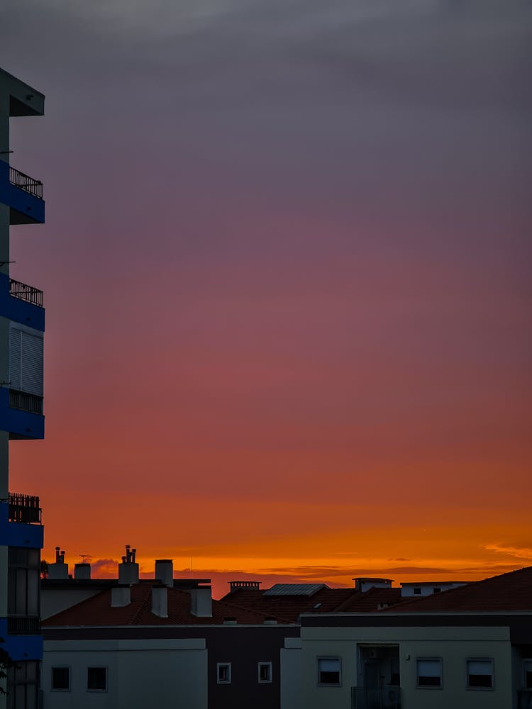 Cloud Over Building In Town At Sunset